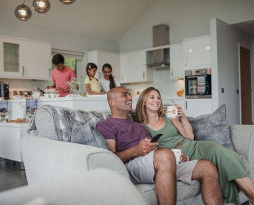 How to make your new house feel like home. Family relaxing on couch and kitchen after recently moving into house.